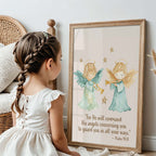 Young girl in a white dress sitting next to a framed print of two angel illustrations with a biblical verse.